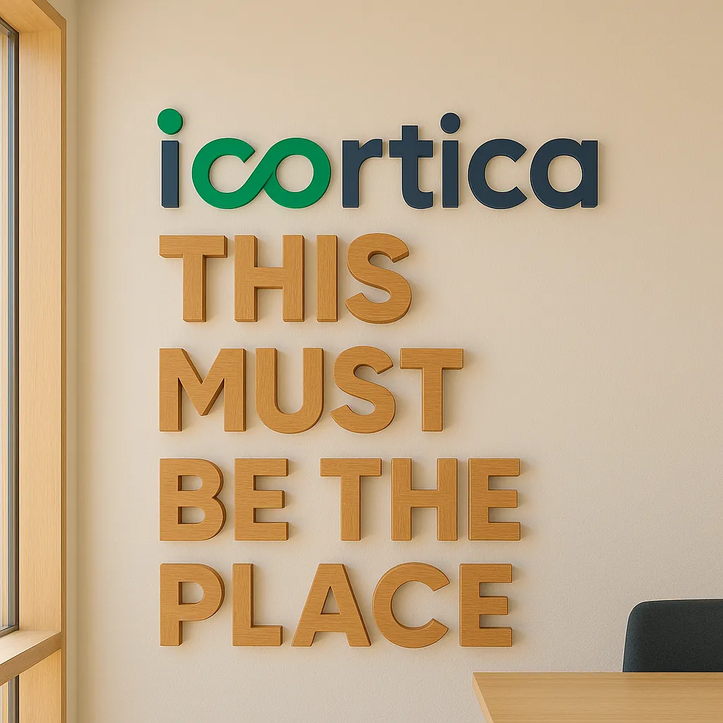 Wall sign with the words "icarta" in green and navy blue letters, and the phrase "THIS MUST BE THE PLACE" in large wooden letters.